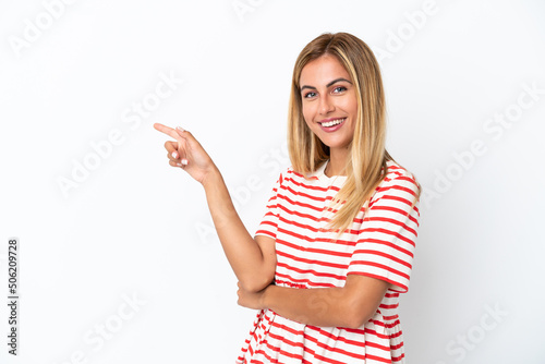 Blonde Uruguayan girl isolated on white background pointing finger to the side
