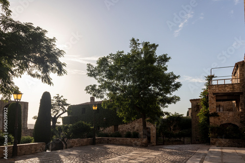 stone square in the medieval village of pals on the bava coast on a summer day at sunset photo