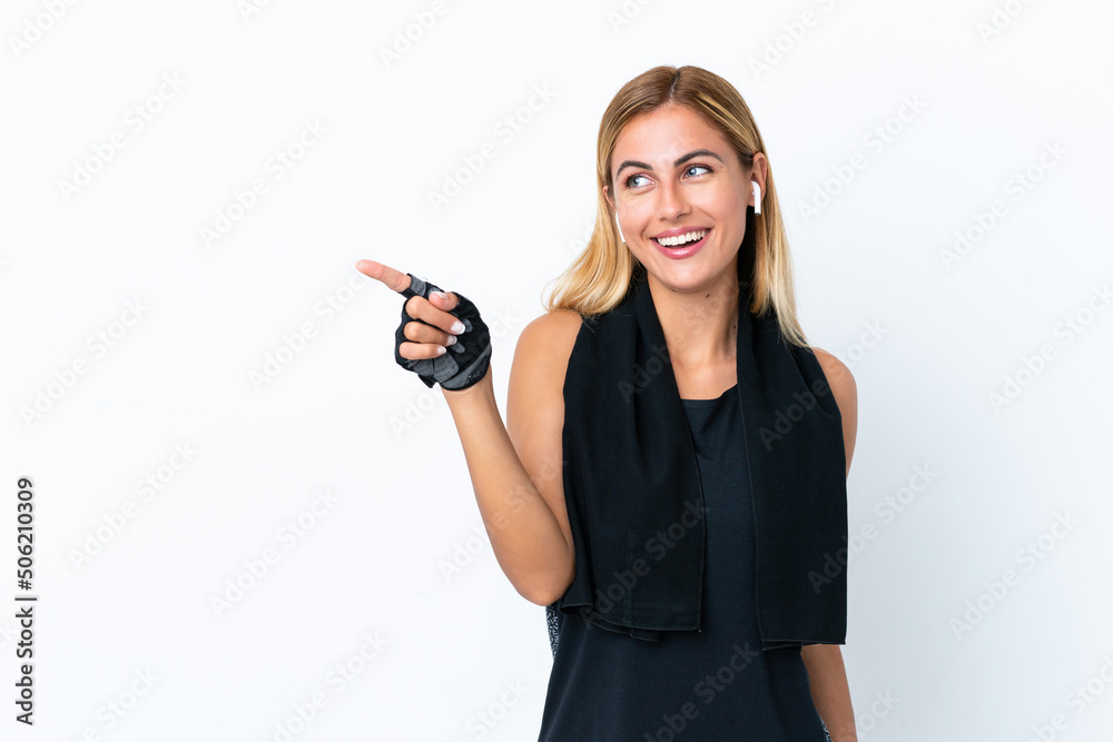 Blonde Uruguayan sport girl isolated on white background pointing finger to the side and presenting a product Blonde Uruguayan sport girl isolated on white background pointing finger to the side and presenting a product
