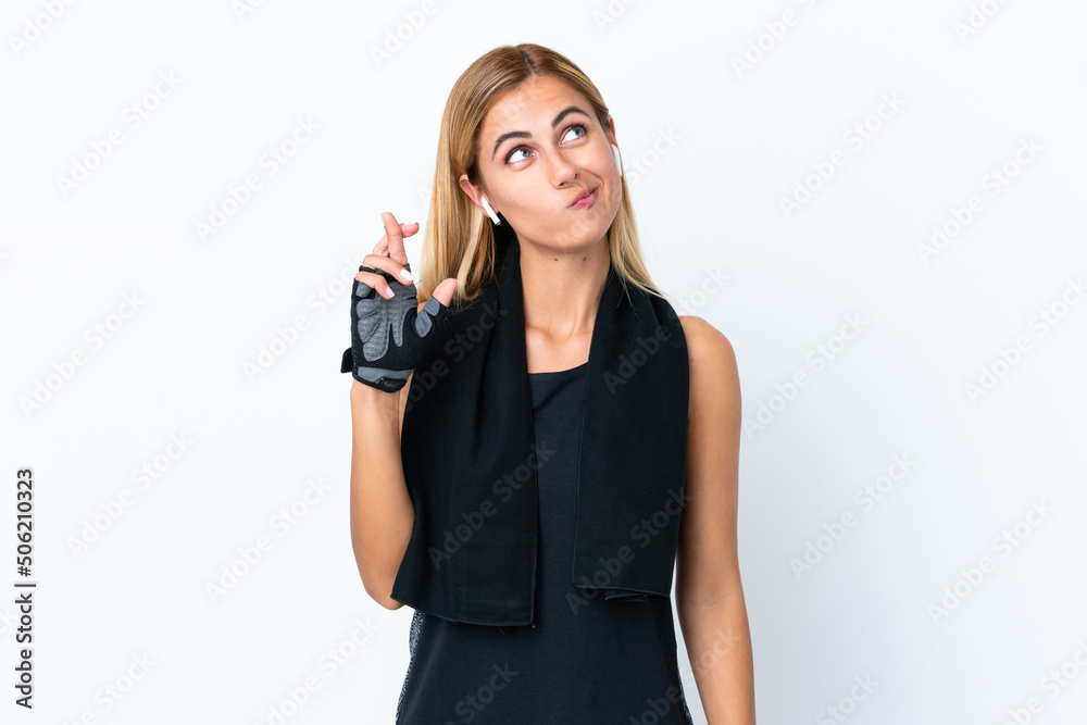 Blonde Uruguayan sport girl isolated on white background with fingers crossing and wishing the best Blonde Uruguayan sport girl isolated on white background with fingers crossing and wishing the best