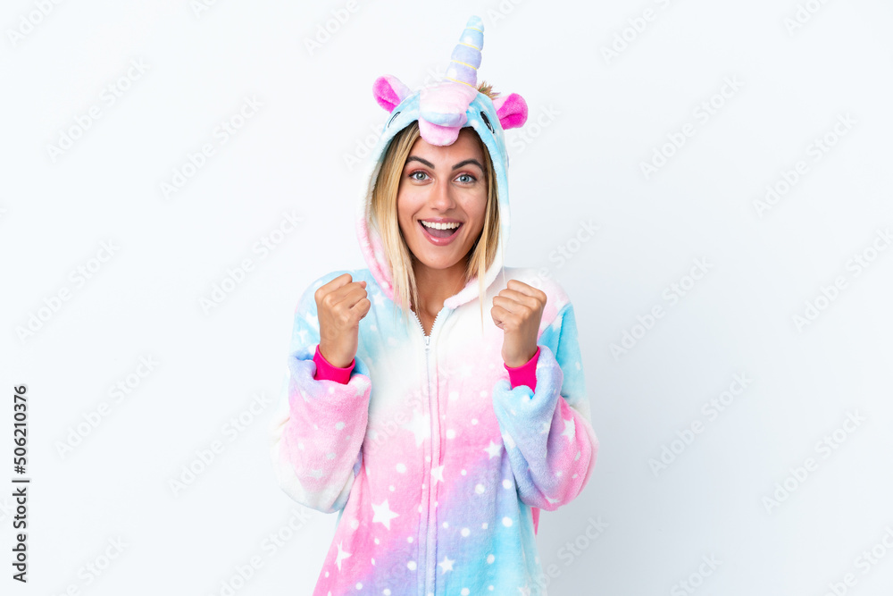 Blonde Uruguayan girl wearing a unicorn pajama isolated on white background celebrating a victory in winner position Blonde Uruguayan girl wearing a unicorn pajama isolated on white background celebrating a victory in winner position