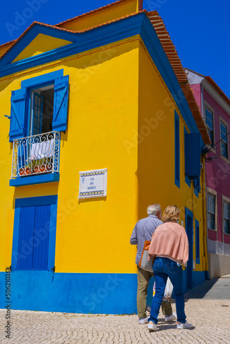 Tourists near Typical portugal multicolored yellow and blue house in Aveiro city