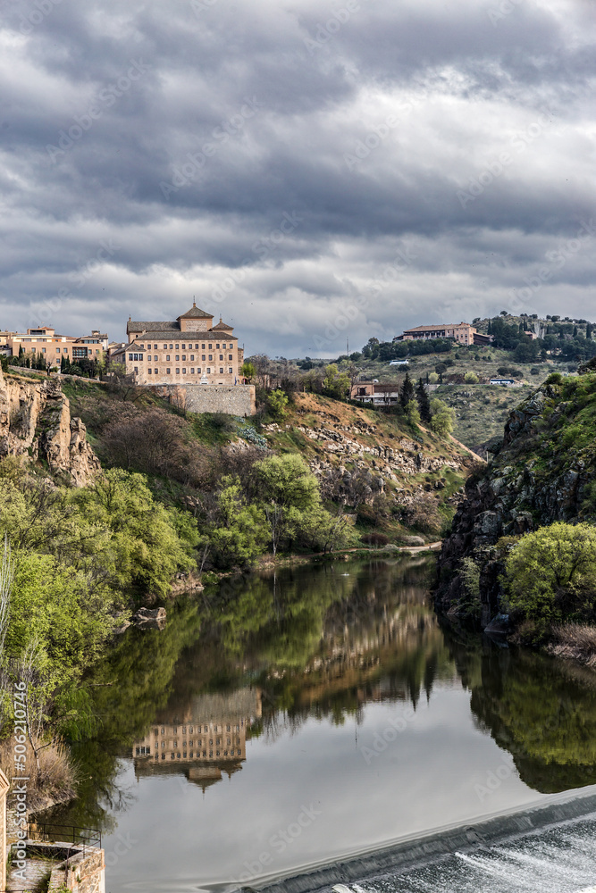 Tajo River with reflection of mountains and buildings