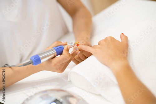 Woman in a nail salon receiving a manicure by a beautician with.