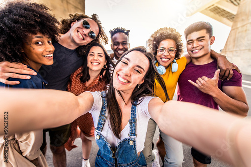 Multiracial group of friends taking selfie with smart mobile phone - Happy millenial people laughing together at camera - Different students having fun in college campus - Friendship concept © Davide Angelini