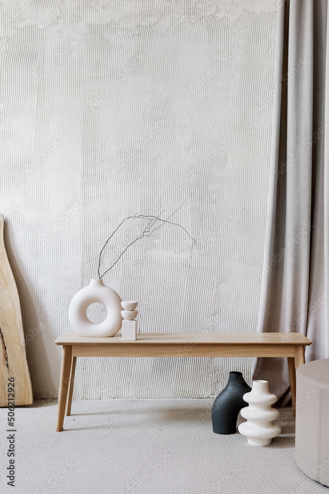 Ceramic vases with branches in room with textured walls - obrazy, fototapety, plakaty 
