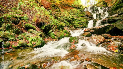 Ukpaine. Waterfall among the mossy rocks. Beautiful landscape rapids on a mountains river in autumn forest in carpathian mountains at sunset. Silver stream in National park Shypit Carpat. Pilipets. photo