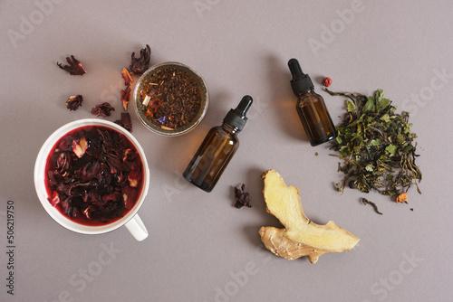 dropper bottles and hibiscus brewed tea on a gray background, culminating drinks concept, adaptogens