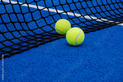 Blue artificial grass paddle tennis court two balls near the net © Vic