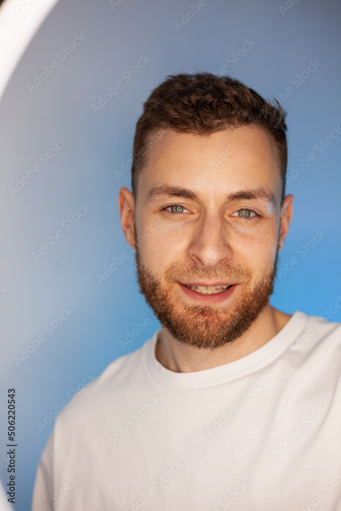 Man shots a video on a phone with a ring lamp, portrait video blogger streaming in neon light Man shots a video on a phone with a ring lamp, portrait video blogger streaming in neon light
