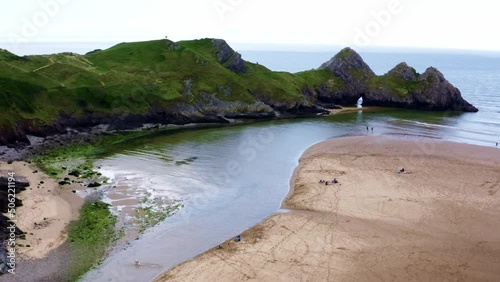 Aerial drone view flying around three cliffs at high tide. Three Cliffs Bay, Gower, Wales photo