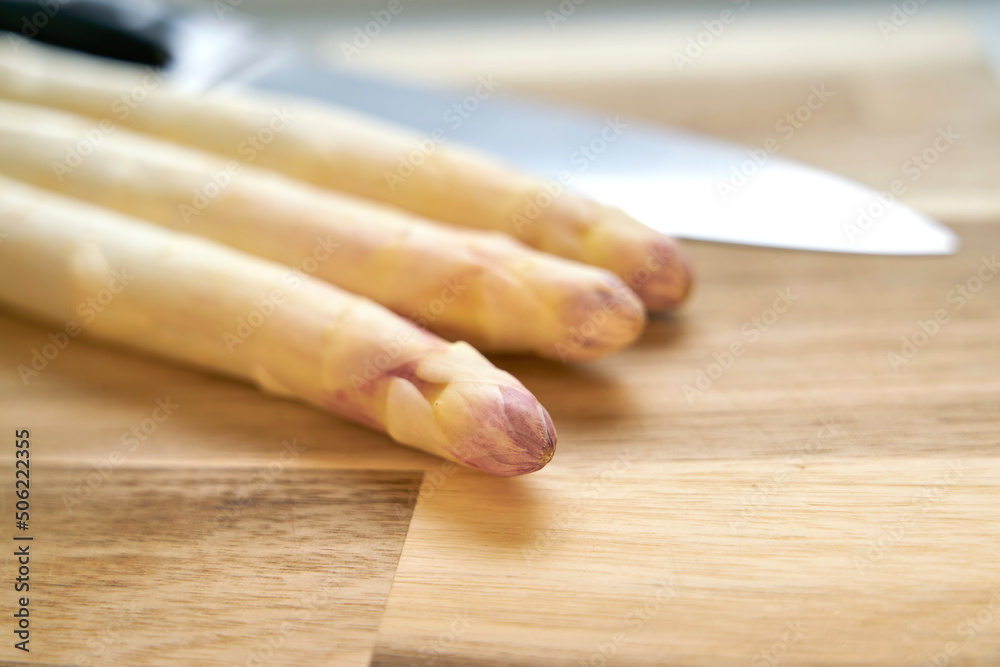 Peeled white asparagus on a kitchen table