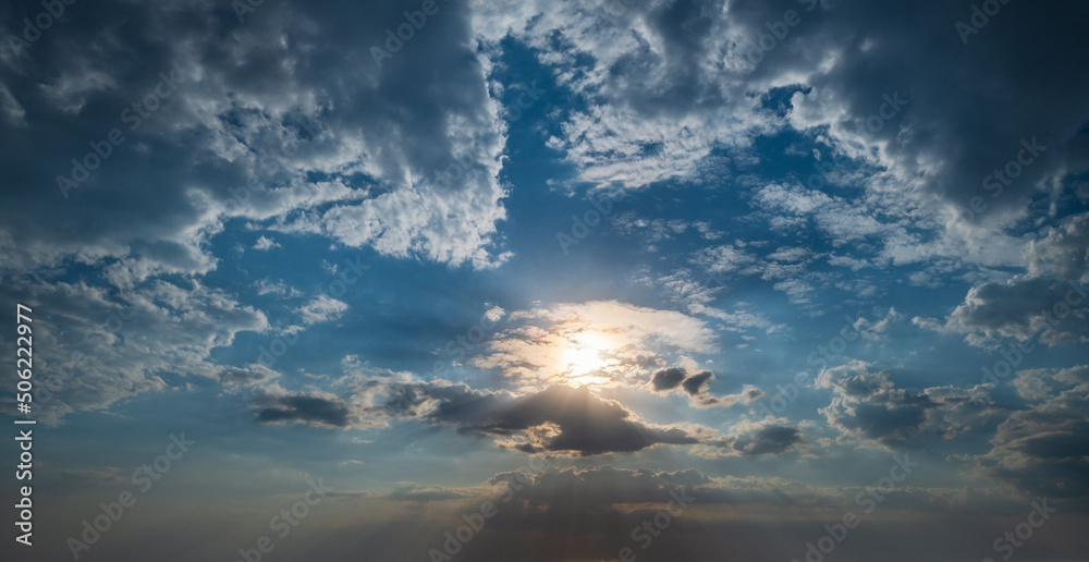Summer sunset sky with sunshine and fleece colorful clouds. Evening dusk good weather natural background.