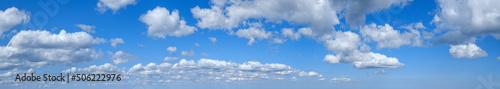 Blue sky with clouds in sunshine (wide natural cloudscape background panorama)