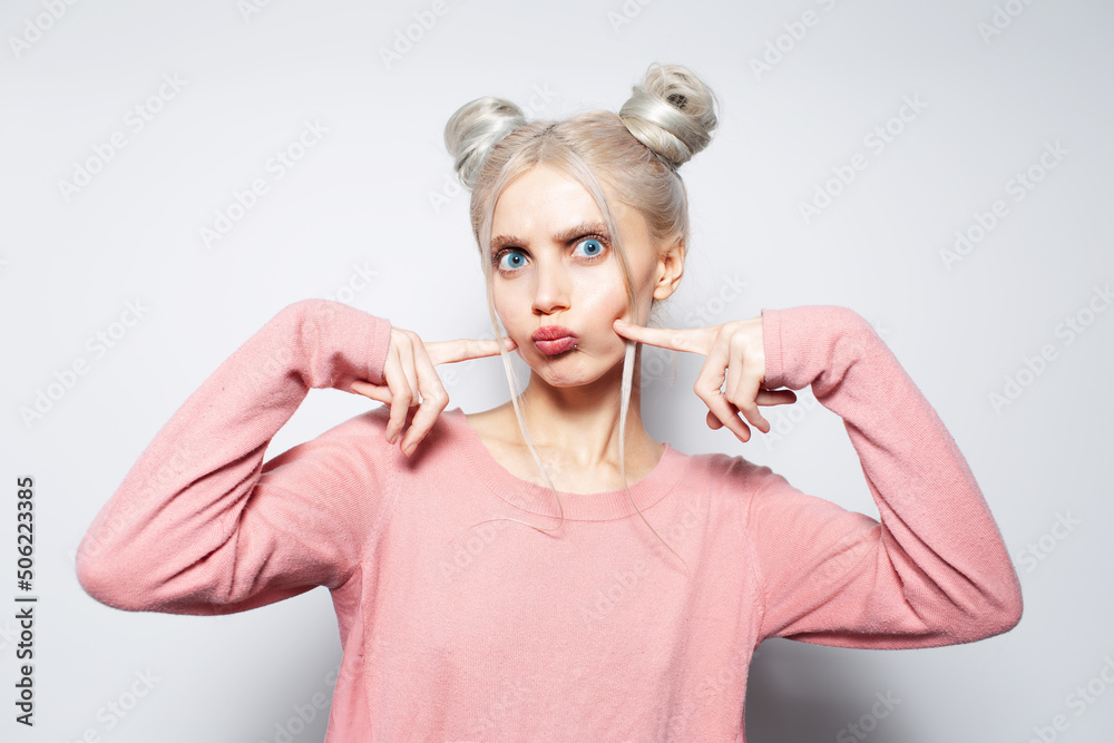 Portrait of funny cute girl touching cheeks with fingers, on white background. Portrait of funny cute girl touching cheeks with fingers, on white background.