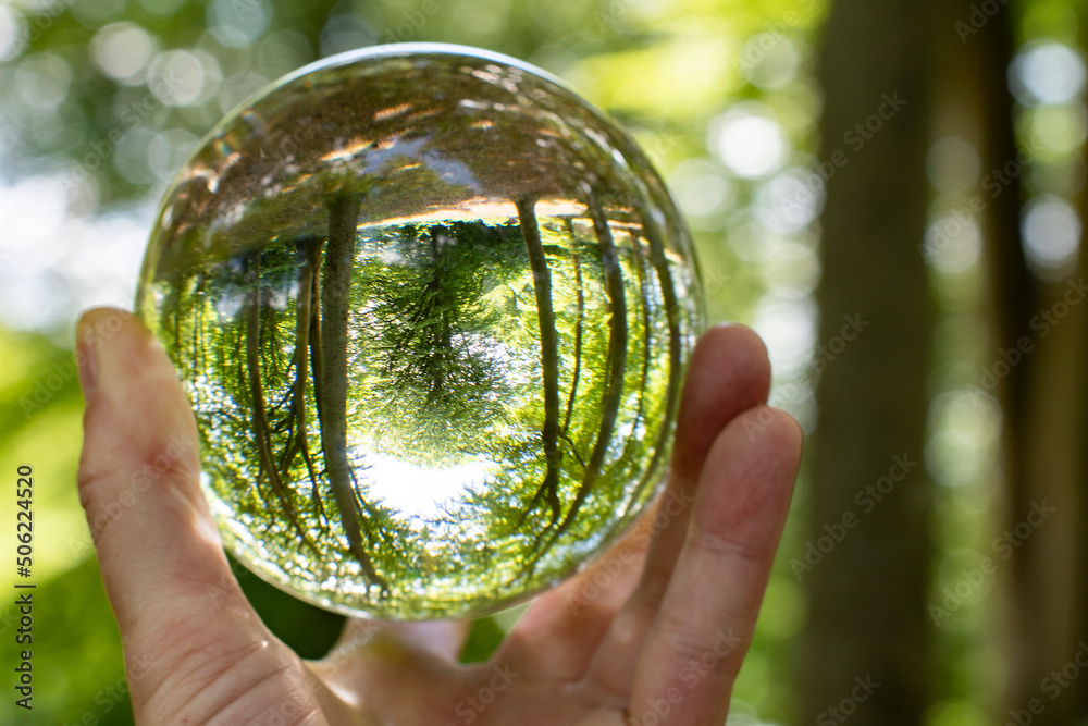 Focus on taking care of nature and the climate shown with nature encased in a luminous crystal ball hold by a womans hand 