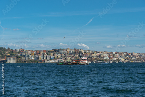View of a ship sailing through the Bosphorus against the background of a densely built-up hill on the Anatolian side of Istanbul, Turkey photo