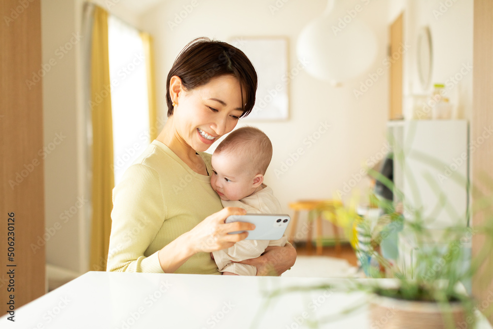 スマートフォンで動画を見る赤ちゃんと母親 スマートフォンで動画を見る赤ちゃんと母親