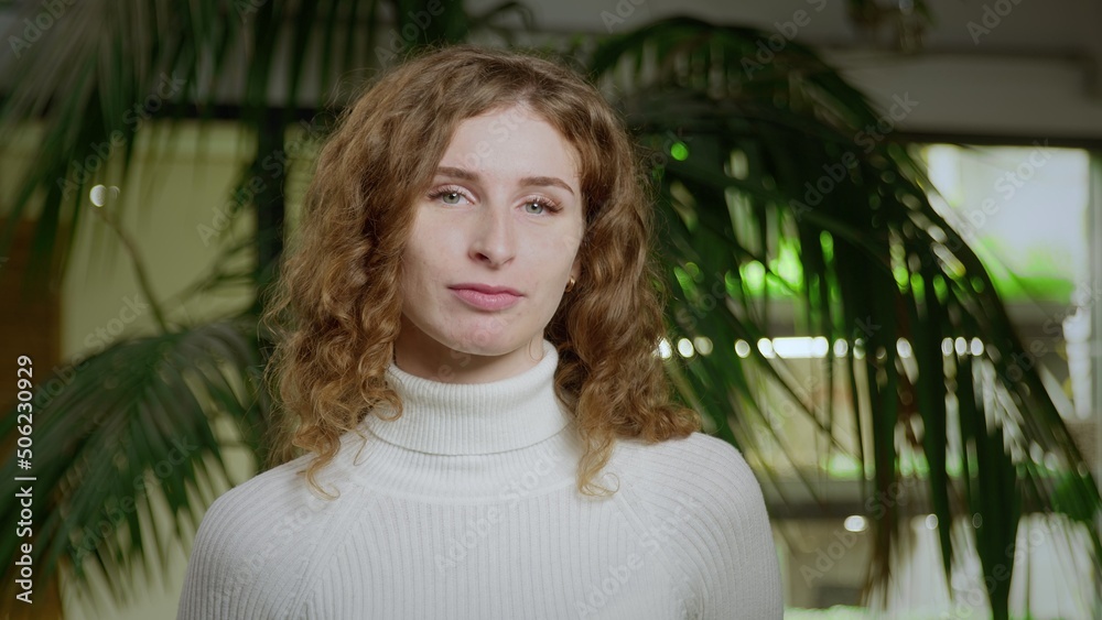 Close-up of a young woman with red hair looking into the camera. Portrait of a Girl Close-up of a young woman with red hair looking into the camera. Portrait of a Girl