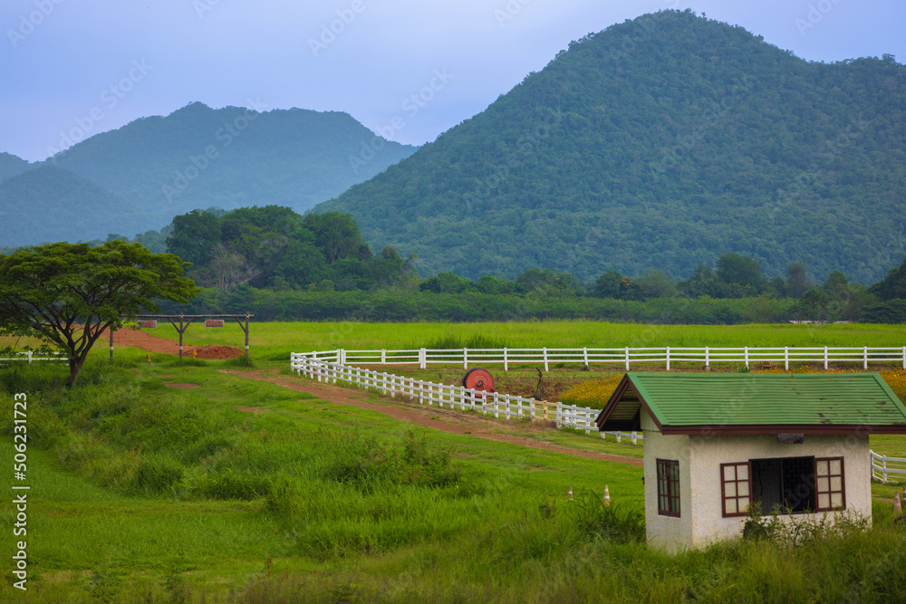 The green ranch behind the mountain has a bright blue sky. The green ranch behind the mountain has a bright blue sky.