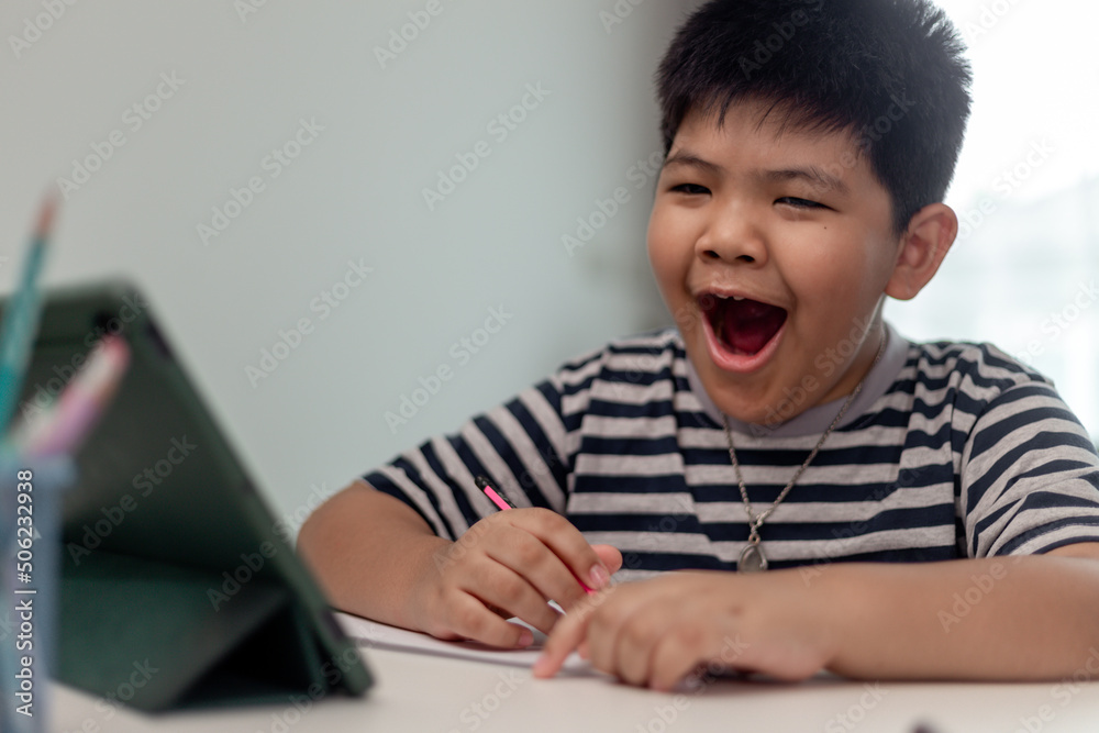 Asian child is yawning and bored while studying online at home Asian child is yawning and bored while studying online at home