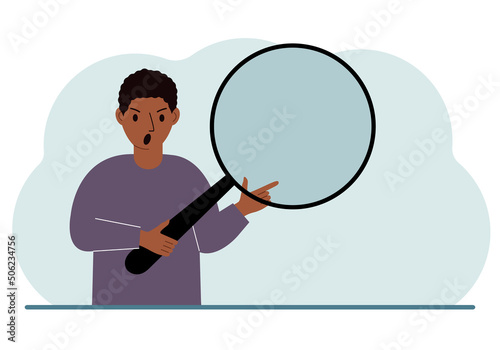 A man holds a large loupe or magnifying glass in his hands.