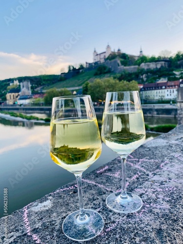 glass of white wine on the old main Bridge with Festung Marienberg Würzburg photo
