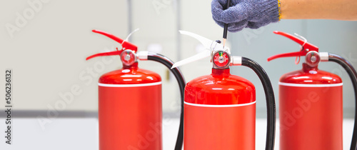 Fire extinguisher has hand engineer inspection checking pressure gauges to prepare fire equipment for protection and prevent emergency and safety rescue and alarm system training concept. photo