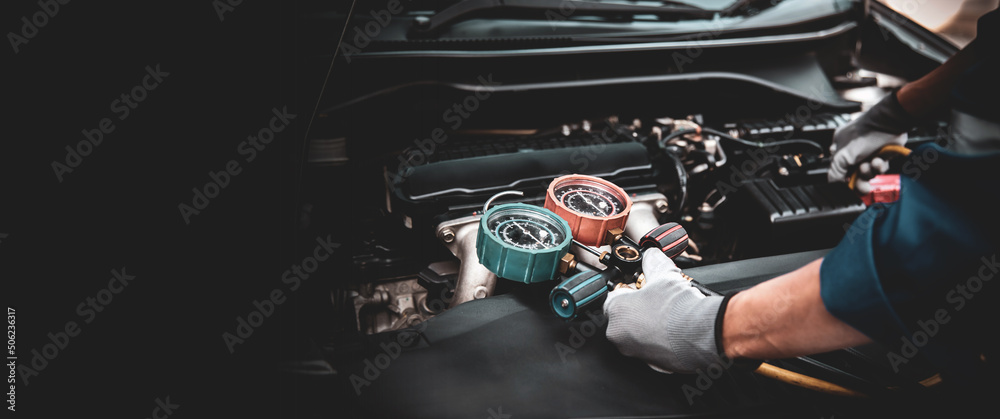 Close up hand of auto mechanic using measuring manifold gauge check the refrigerant and filling car air conditioner for fix and checking for repair service support maintenance and car insurance. - obrazy, fototapety, plakaty 