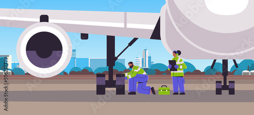 aviation supervisors mechanic and marshal in signal vests engineers checking aircraft landing gear wheel professional airport staff