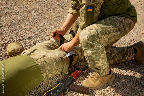Konstfotografi Army medics practice applying a tourniquet to the leg of a wounded soldier