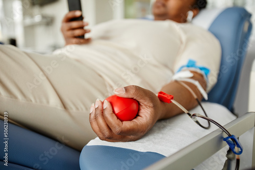 Foto Close up of young black woman squeezing stress ball while giving blood at donati