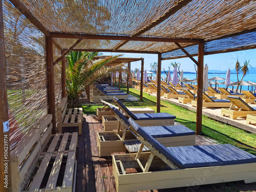 sea beach bar umbrellas and chairs by sand in preveza, monolithi beach greece