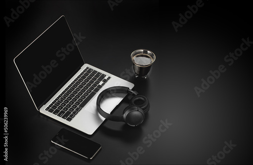 Workspace mockup template  on black structural background. Musician composer workplace with headphones, laptop, phone and cup of coffee

