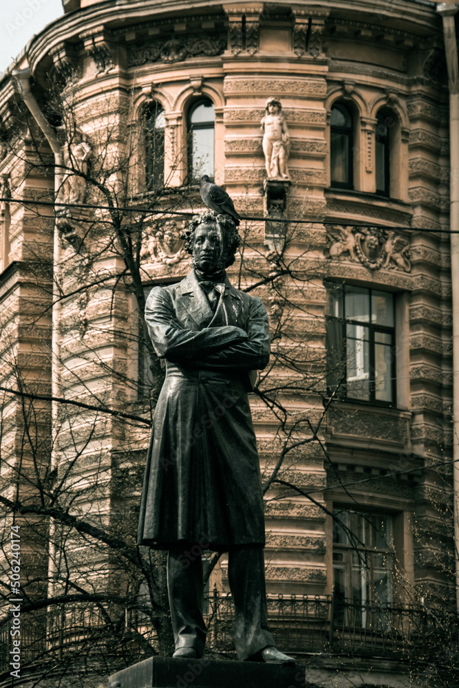 Fototapeta premium Monument to Pushkin, a pigeon sitting on its head, photo on the street