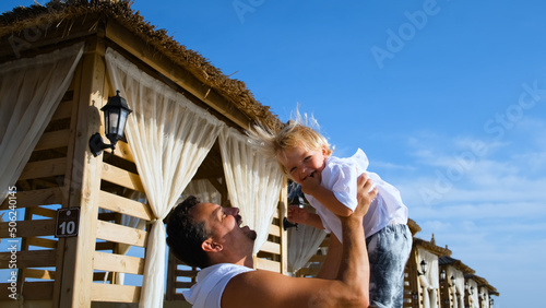 Photography dad tosses his son up at a beach resort