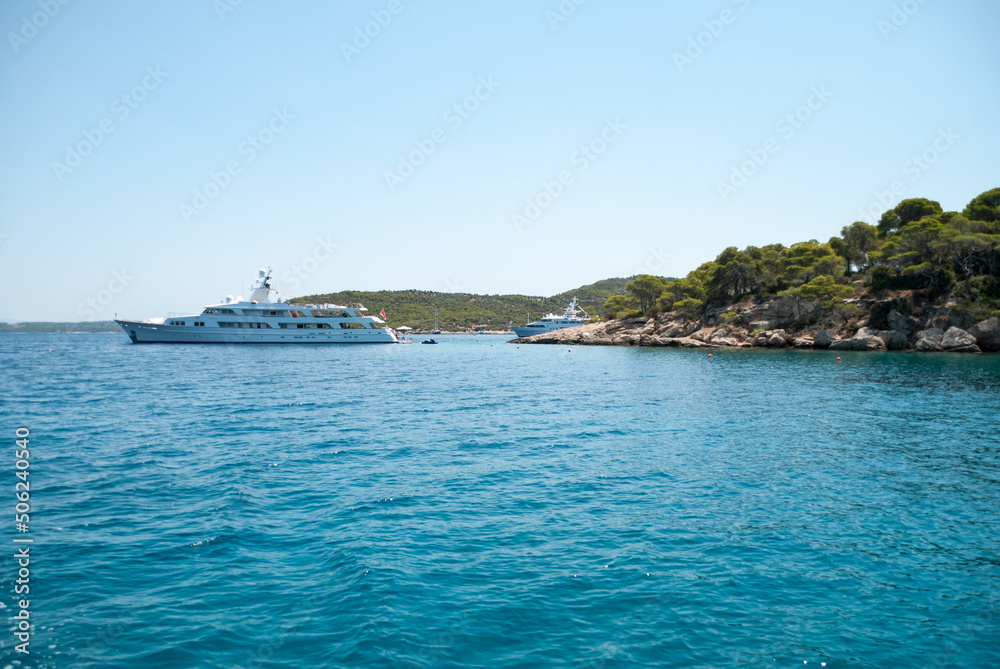 Yacht on clear turquoise waters of a Spetses island bay