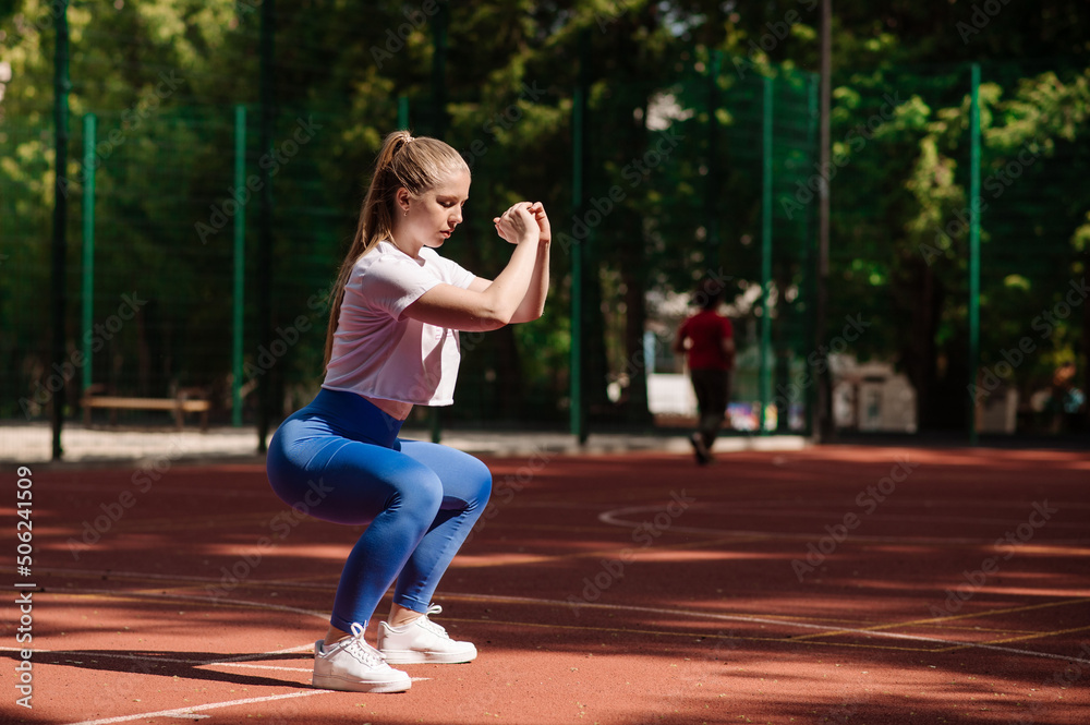 Pretty caucasian fitness woman in sports wear doing morning exercises on sport ground outdoor Pretty caucasian fitness woman in sports wear doing morning exercises on sport ground outdoor