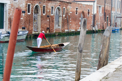 Un uomo voga alla veneziana in un canale del sestiere di Cannaregio photo
