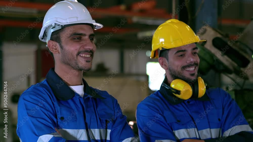 Engineer smiling while standing in factory. Safety hard hat prevent accident and various equipment in industrial factory. Engineer smiling while standing in factory. Safety hard hat prevent accident and various equipment in industrial factory.
