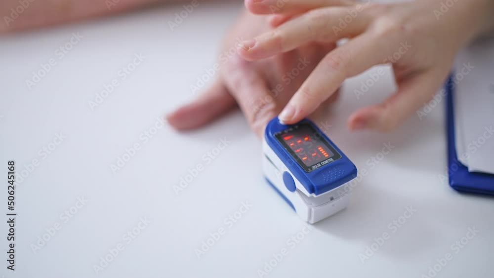 Therapist checking patient's oxygen saturation level of blood, hands close-up