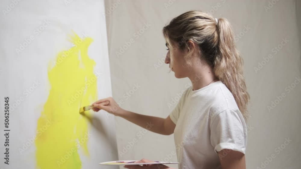 modern woman painting on canvas on plain background, studio shot modern woman painting on canvas on plain background, studio shot
