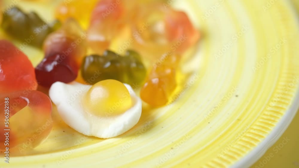 gummy candies on a plate on yellow background . gummy candies on a plate on yellow background .