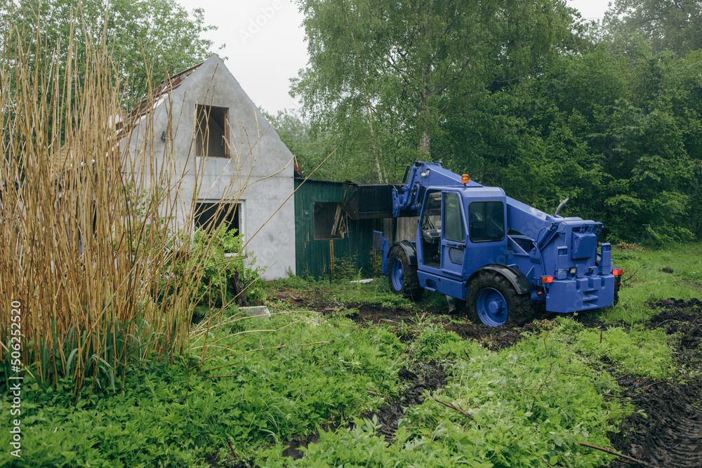 with one wheel loader an old, dilapidated house is demolished