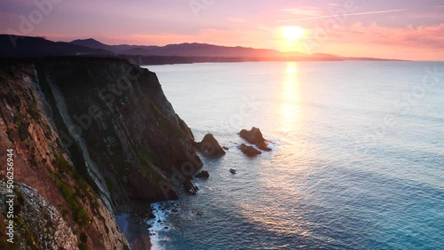 Sunset over rocky cliffs at Asturias coast in north Spain. View from Faro de Cabo Busto. Tourist attraction, place to visit.