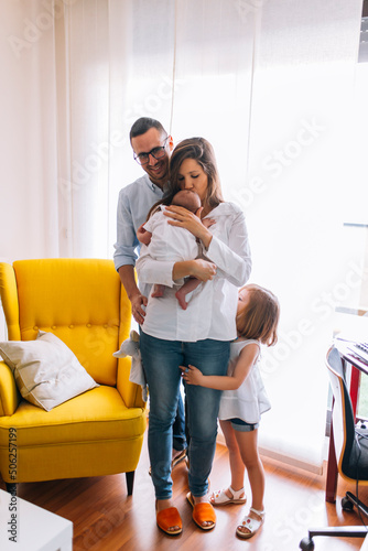 Mom breastfeeding her newborn son with her father and daughter. family of four
