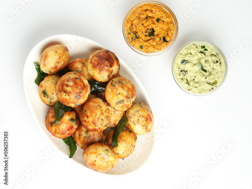 Kuzhi Paniyaram served with coconut chutney and sambar- South Indian breakfast with black lentils and rice photo