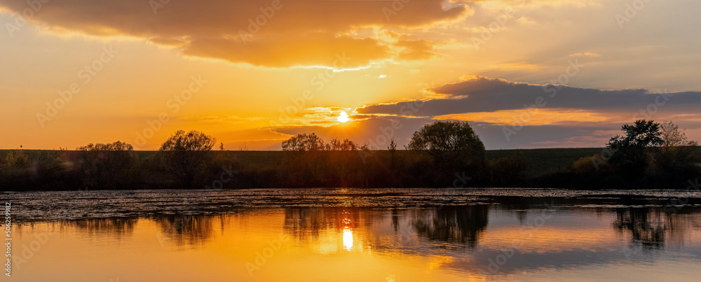 Sunrise or sunset on the river. Reflection of the sky and clouds in the river water Sunrise or sunset on the river. Reflection of the sky and clouds in the river water