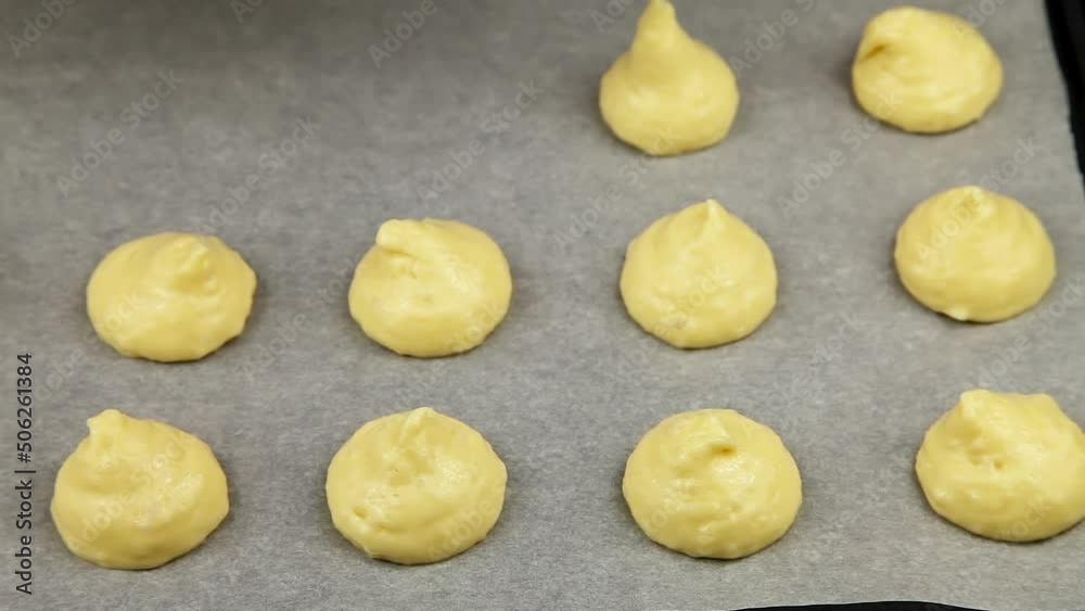 The process of profiterole production. Squeezing the baking dough from the pastry bag. Close up. The process of profiterole production. Squeezing the baking dough from the pastry bag. Close up.