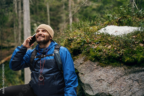 Delighted adventurer using telephone for calling to friend
